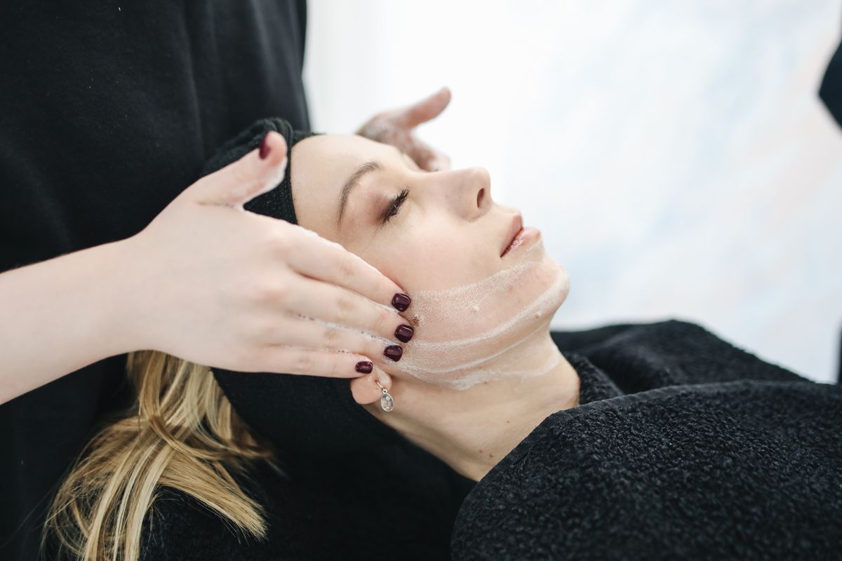 An esthetician performing a facial massage, stock photograph