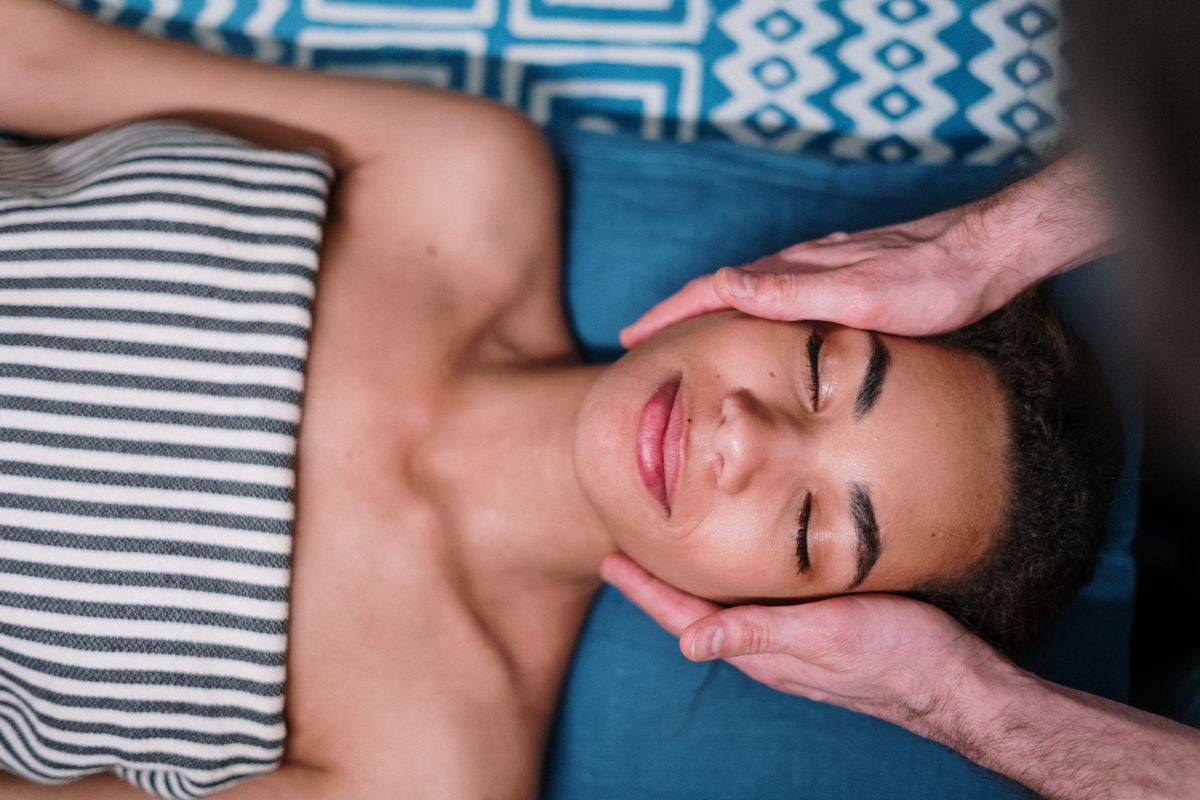 A client reclining during a head massage, stock photograph